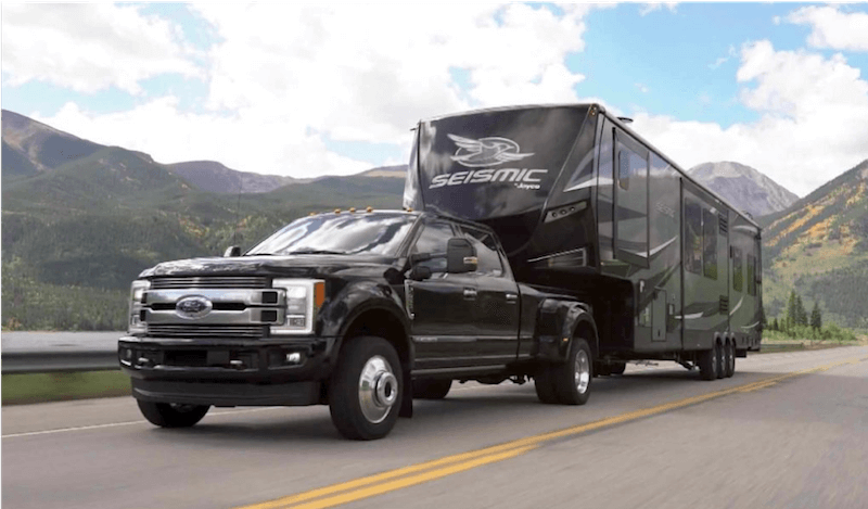 black ford pickup truck towing a camping trailer